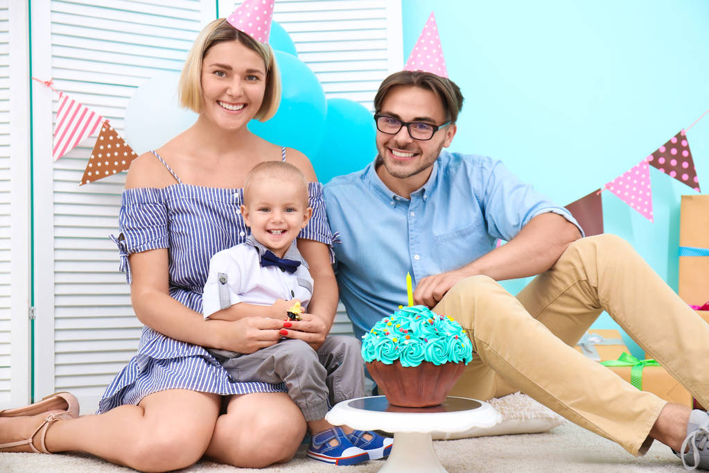 Netter kleiner Junge mit Eltern und Geburtstagstorte zu Hause - Foto, Bild
