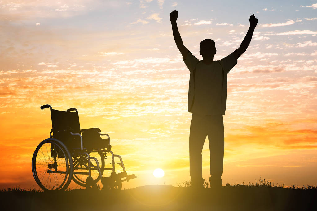 Σιλουέτα του θαύμα αναπηρία άνδρα με τα πόδια και πάλι στο ηλιοβασίλεμα - Φωτογραφία, εικόνα