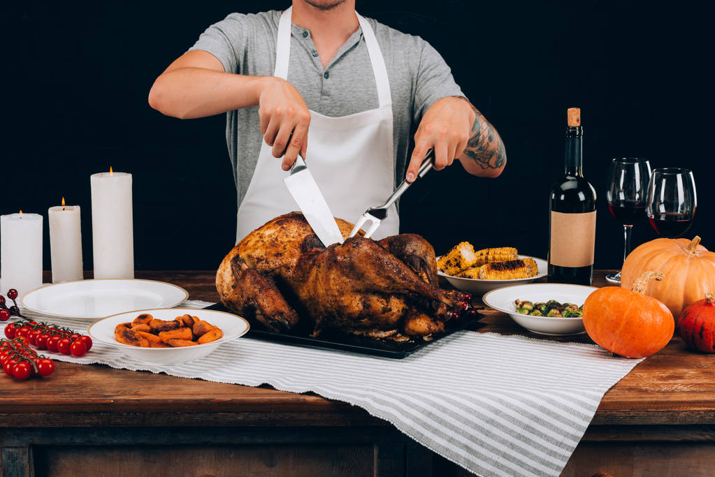Man cutting turkey on thanksgiving day - Photo, Image