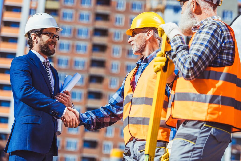 Ouvrier de la construction et homme d'affaires serrant la main
 - Photo, image