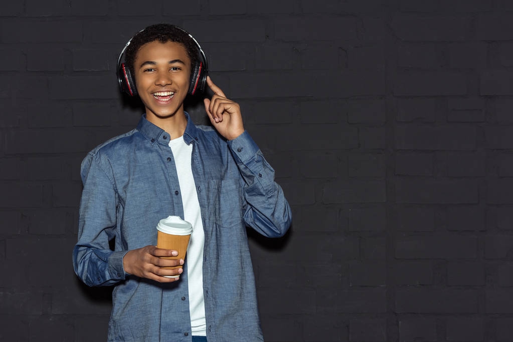menino adolescente com fones de ouvido e café
 - Foto, Imagem
