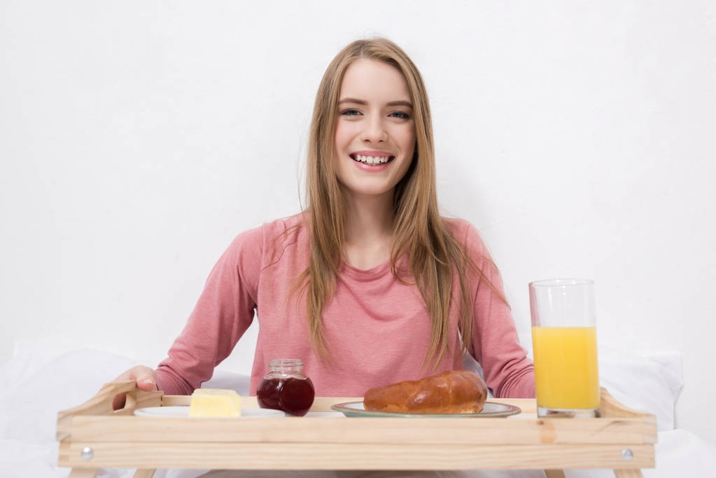 Szczęśliwa kobieta ze śniadaniem na drewniana Taca - Zdjęcie, obraz