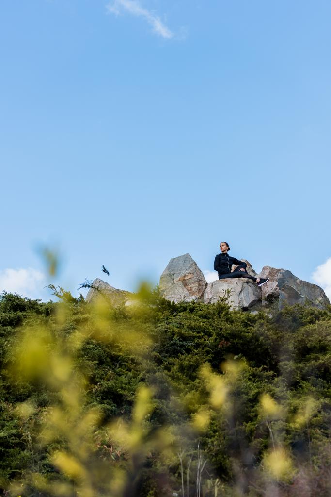 Жінка сидить на скелях
 - Фото, зображення