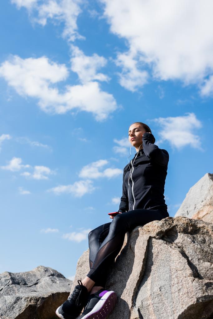 žena sedí na skalách a poslech hudby - Fotografie, Obrázek