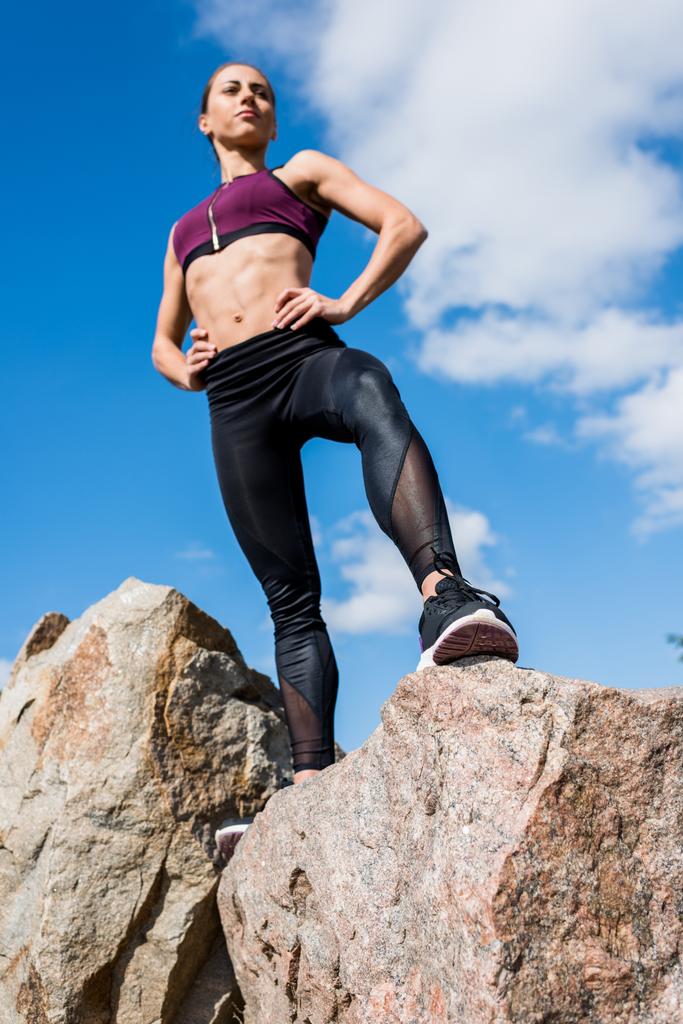 athletic woman standing on rocks - Photo, Image
