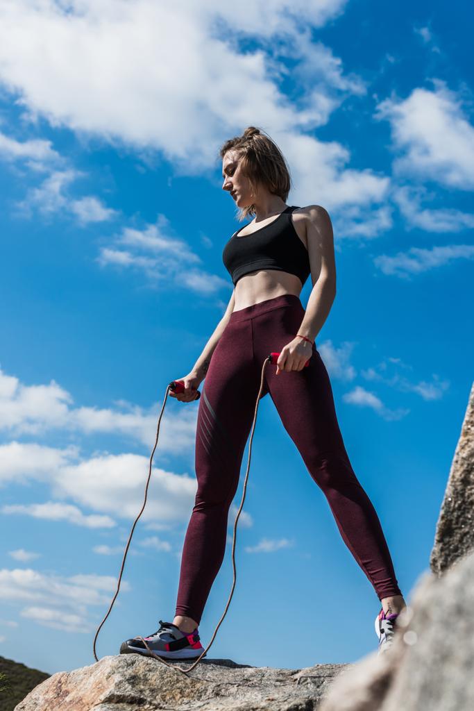 woman on rock with jumping rope - Photo, Image
