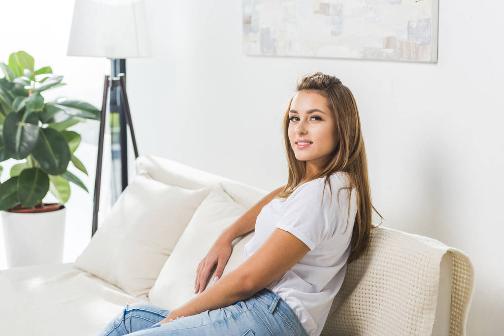 atrakcyjna kobieta siedzi na kanapie - Zdjęcie, obraz