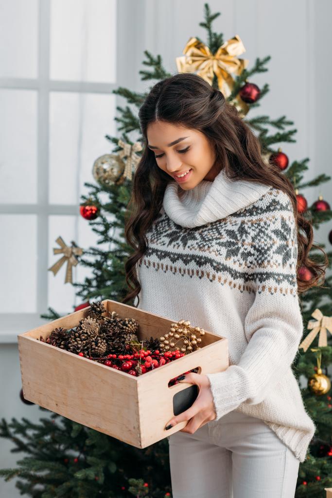 mulher com caixa de decoração de Natal natural
 - Foto, Imagem