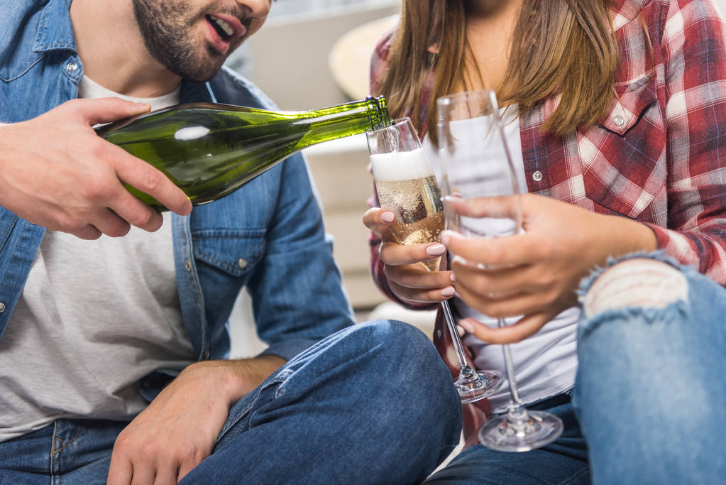 Paar sitzt mit Champagner auf dem Boden - Foto, Bild