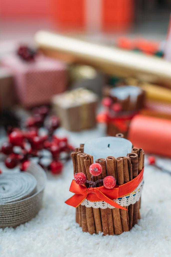 candela natalizia decorata con bastoncini di cannella
 - Foto, immagini