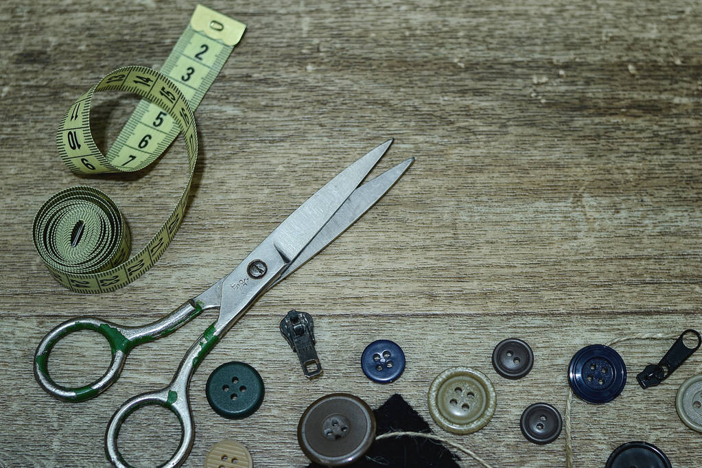 Ножницы и кнопки на деревянном фоне
 - Фото, изображение