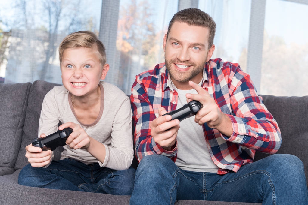 Padre e figlio giocano con i joystick
 - Foto, immagini