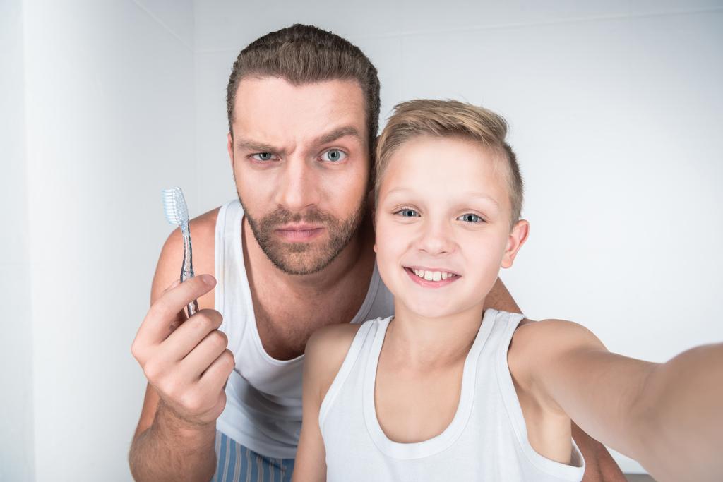 Pai e filho escovando os dentes
 - Foto, Imagem