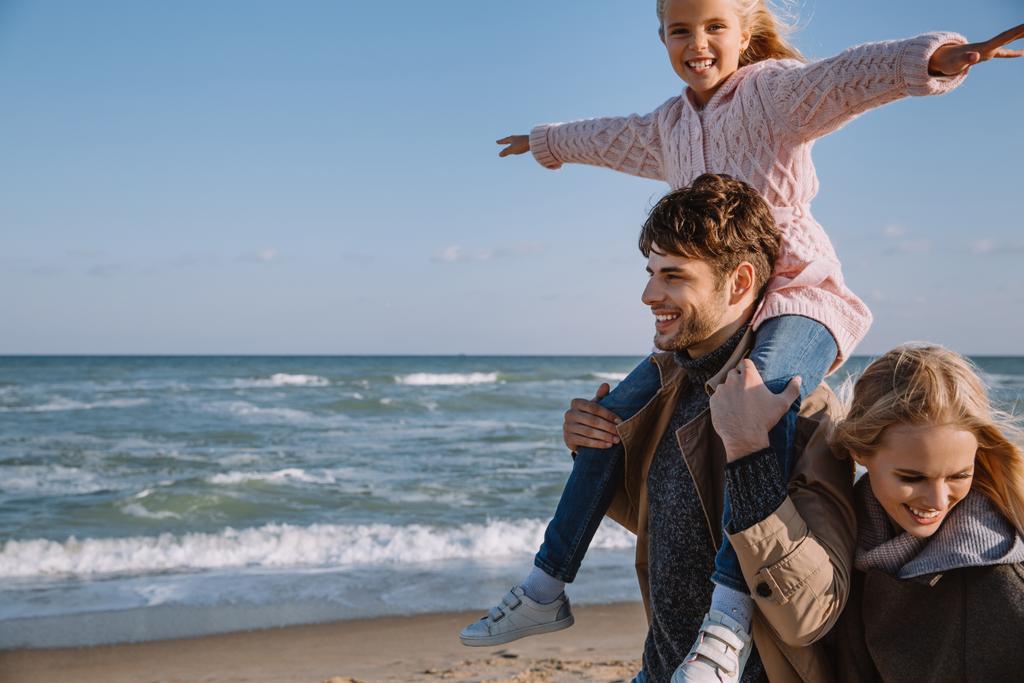 海岸に満足する娘と家族 - 写真・画像