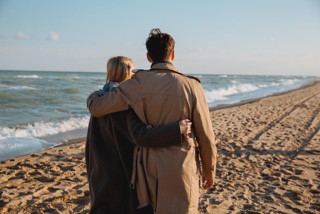 casal abraçando e andando na praia
 - Foto, Imagem