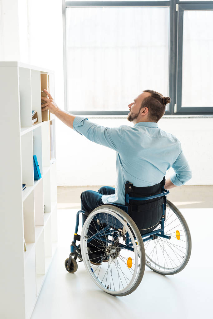 інвалідний бізнесмен досягає шельфу
 - Фото, зображення
