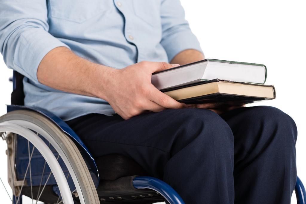 Человек на инвалидной коляске с книгами в руках
 - Фото, изображение
