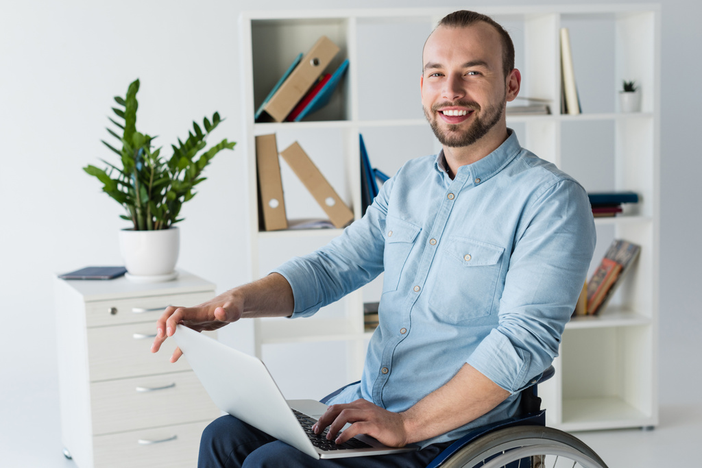 uomo d'affari in sedia a rotelle utilizzando il computer portatile
 - Foto, immagini