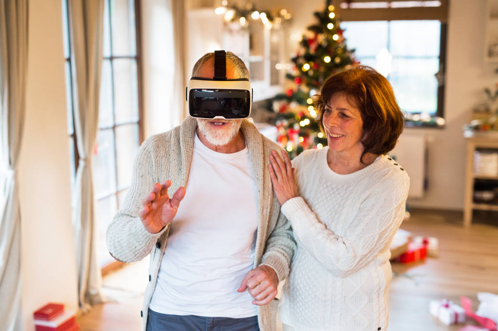 Senior couple in front of Christmas tree with VR goggles. - Photo, Image