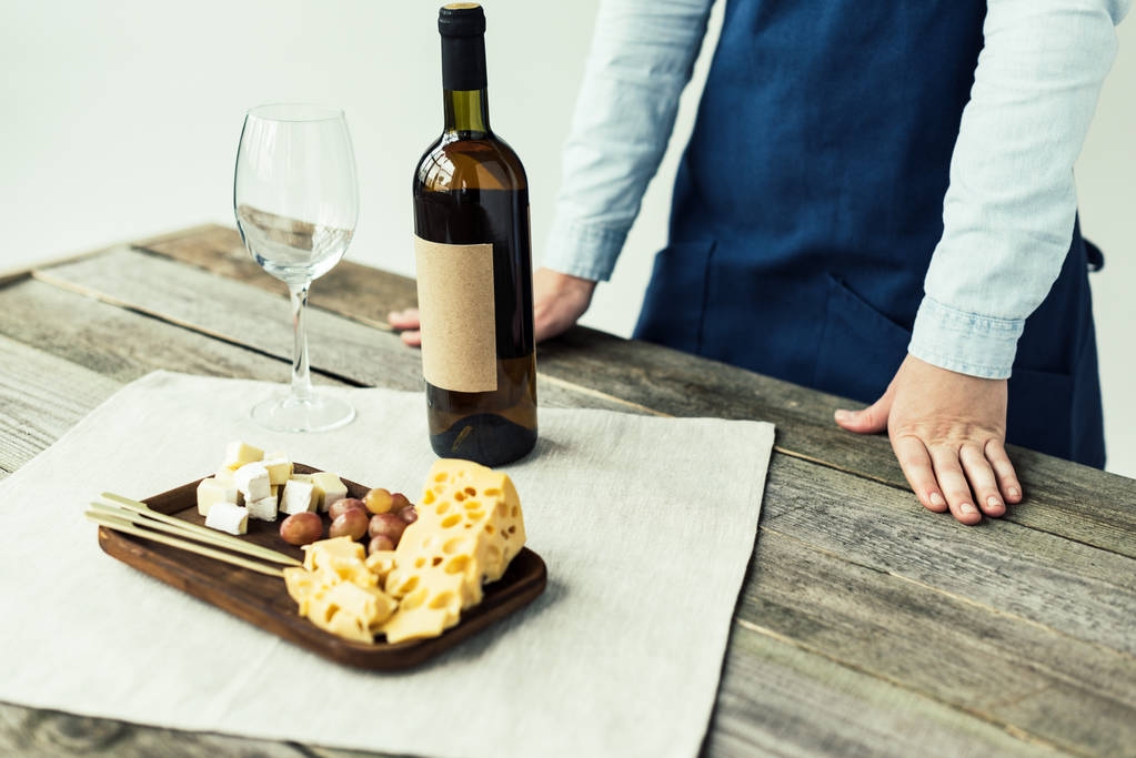 sommelier debout à table avec bouteille de vin
 - Photo, image