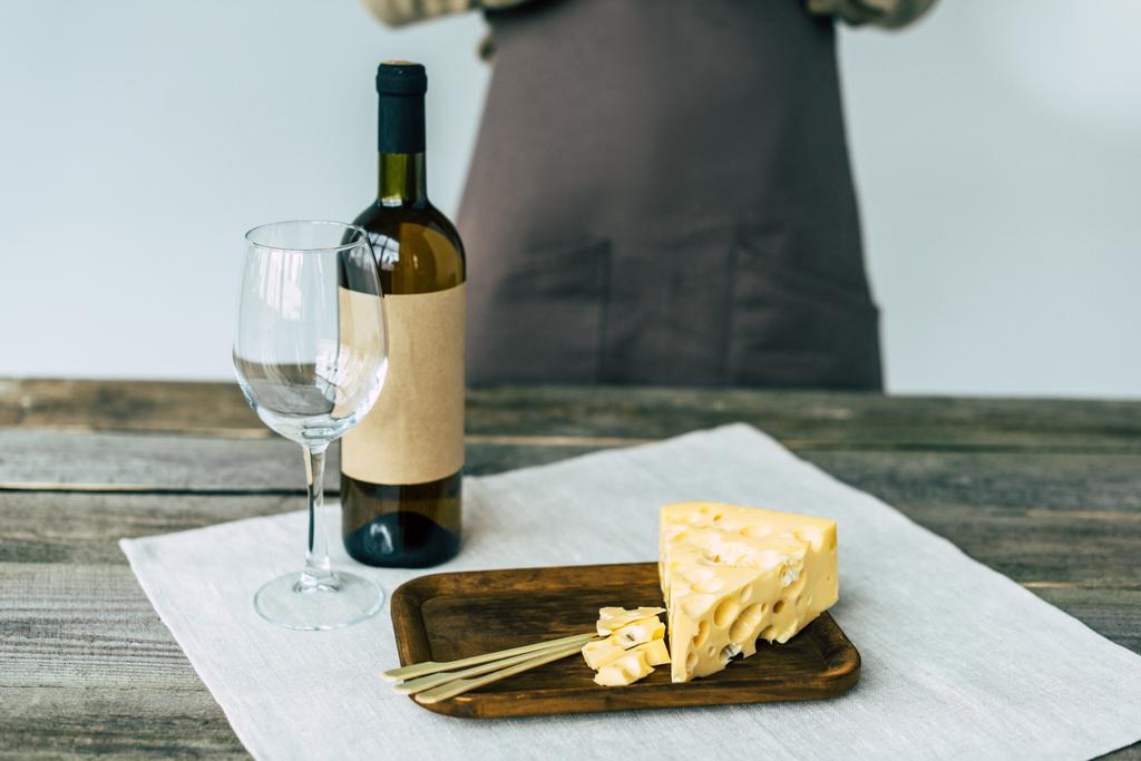 Fles wijn met lege glazen en kaas - Foto, afbeelding