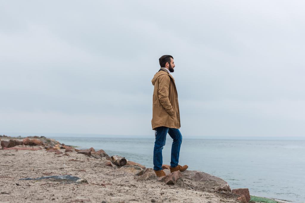 uomo in piedi sulla riva del mare
 - Foto, immagini