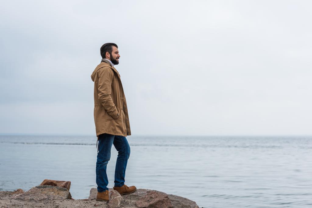 uomo in piedi sulla riva del mare
 - Foto, immagini