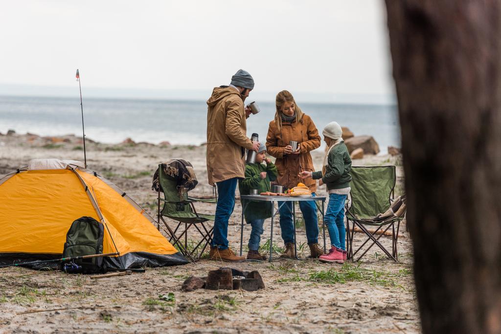 Семья с лагерем на берегу моря
 - Фото, изображение