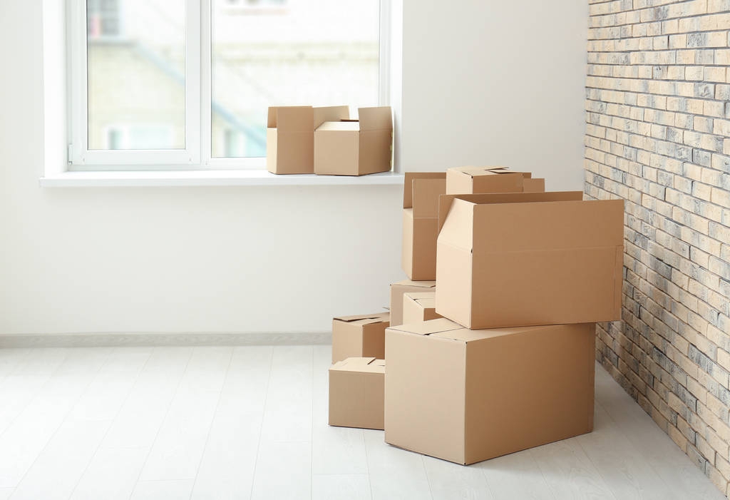 Mover concepto de casa. Cajas de cartón en el suelo en habitación vacía
 - Foto, imagen