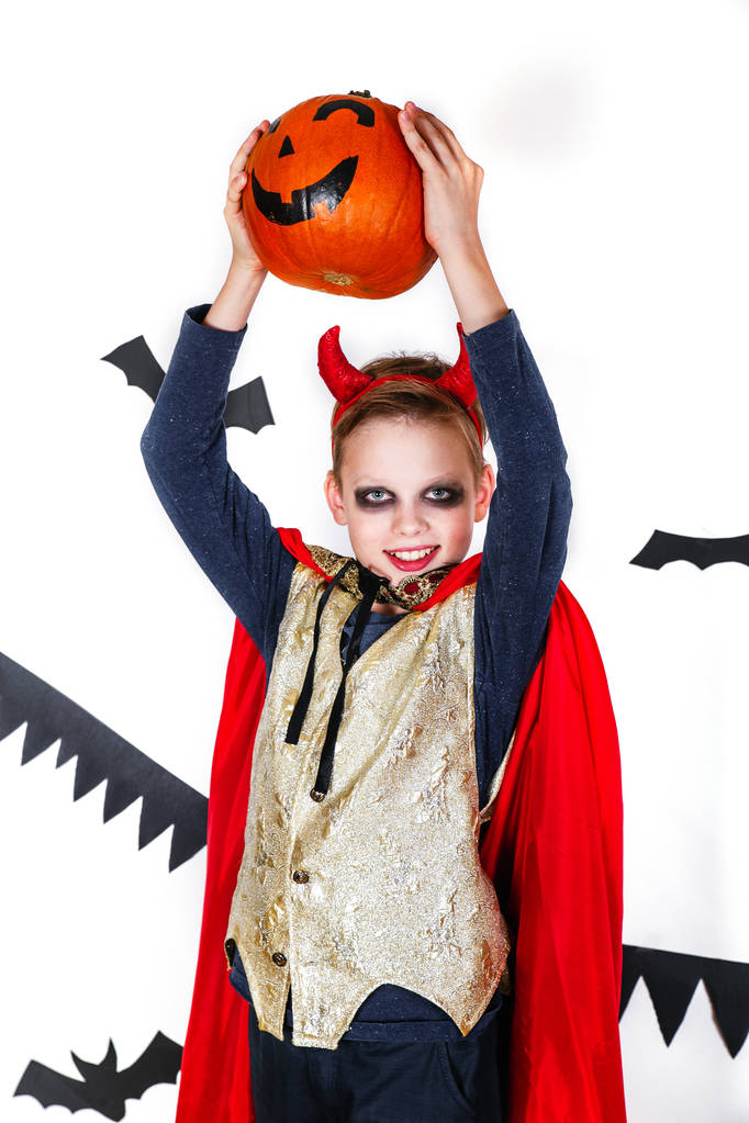 ホリデイ ハロウィーン。かぼちゃの白い背景の上のカーニバル衣装悪魔面白い子 - 写真・画像