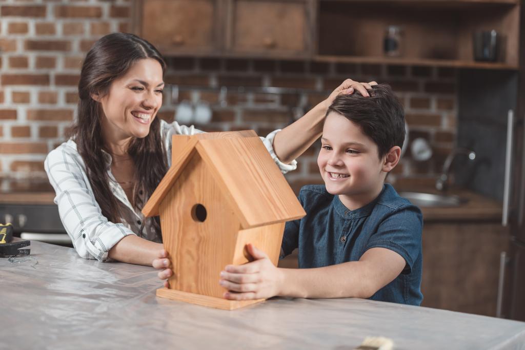 Trots op zoon en moeder met birdhouse - Foto, afbeelding