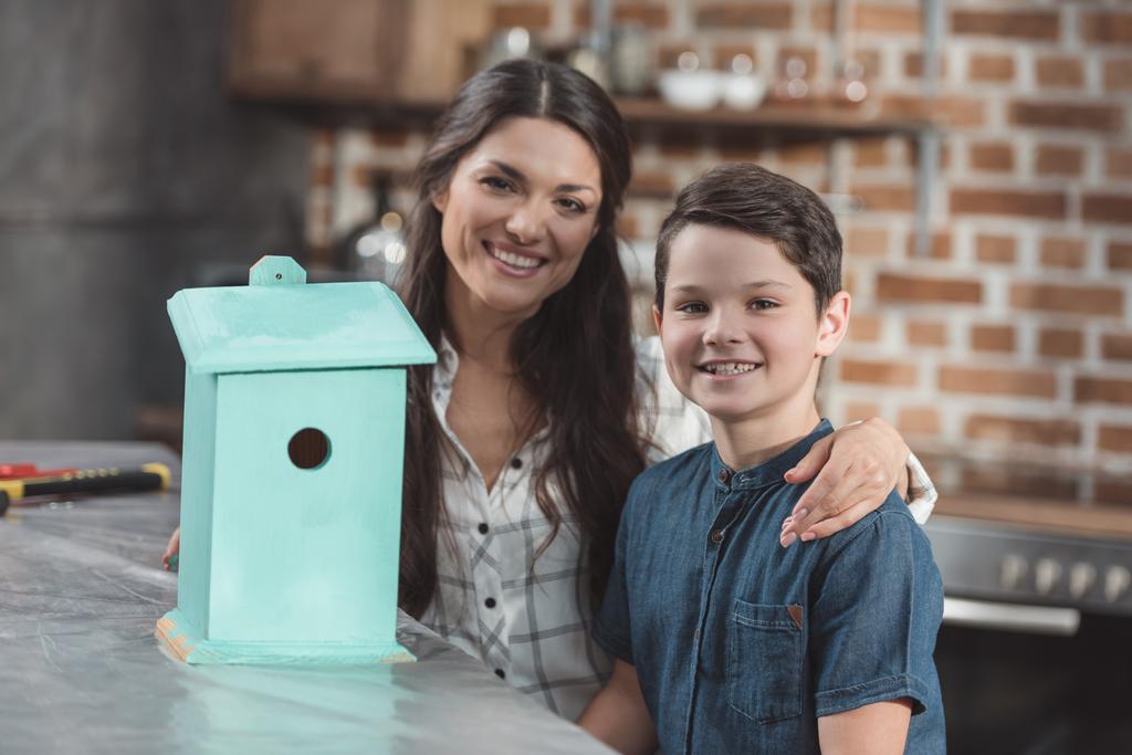 Zoon en moeder met houten birdhouse - Foto, afbeelding