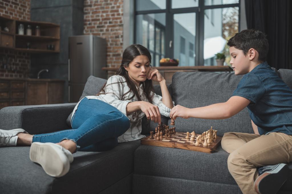Мать и мальчик играют в шахматы
 - Фото, изображение