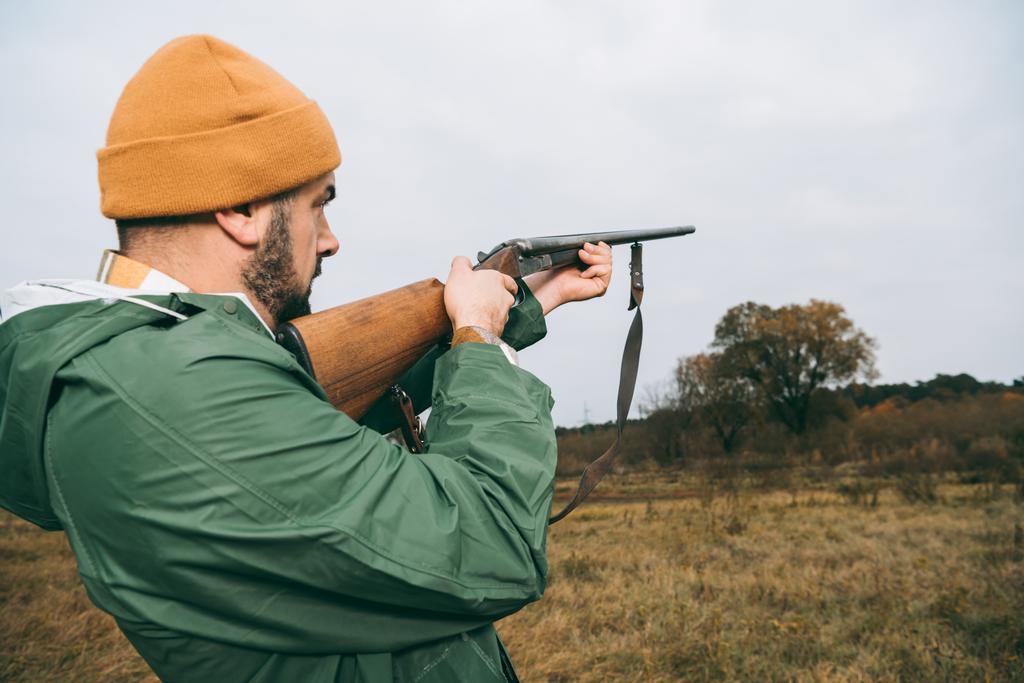 Κυνηγός με στόχο κάτι με πυροβόλο όπλο - Φωτογραφία, εικόνα