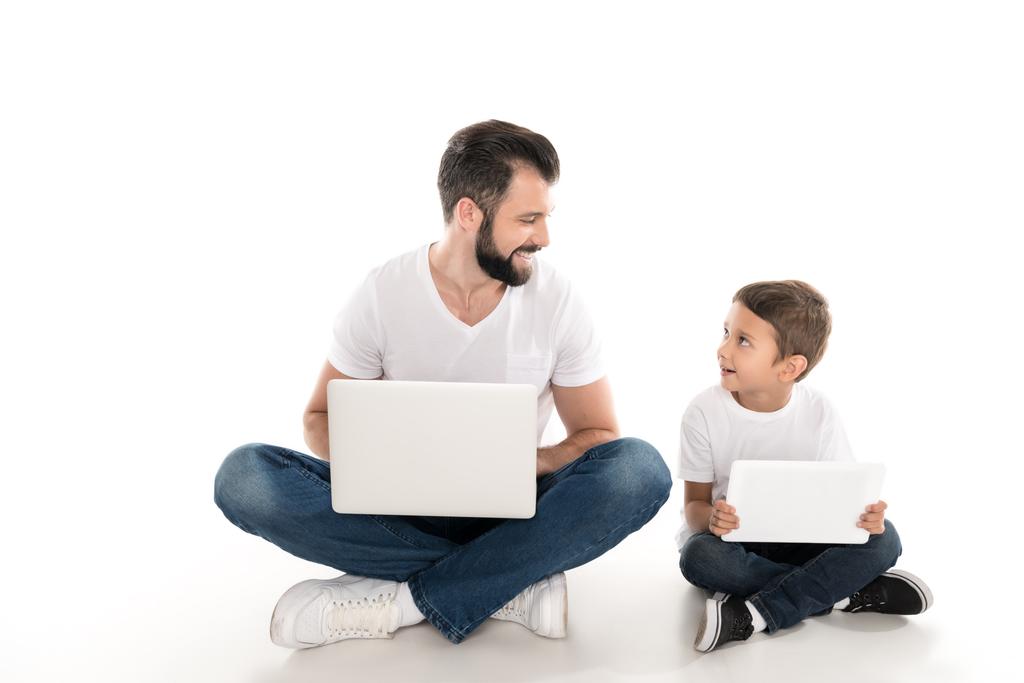 pai e filho com dispositivos digitais
 - Foto, Imagem