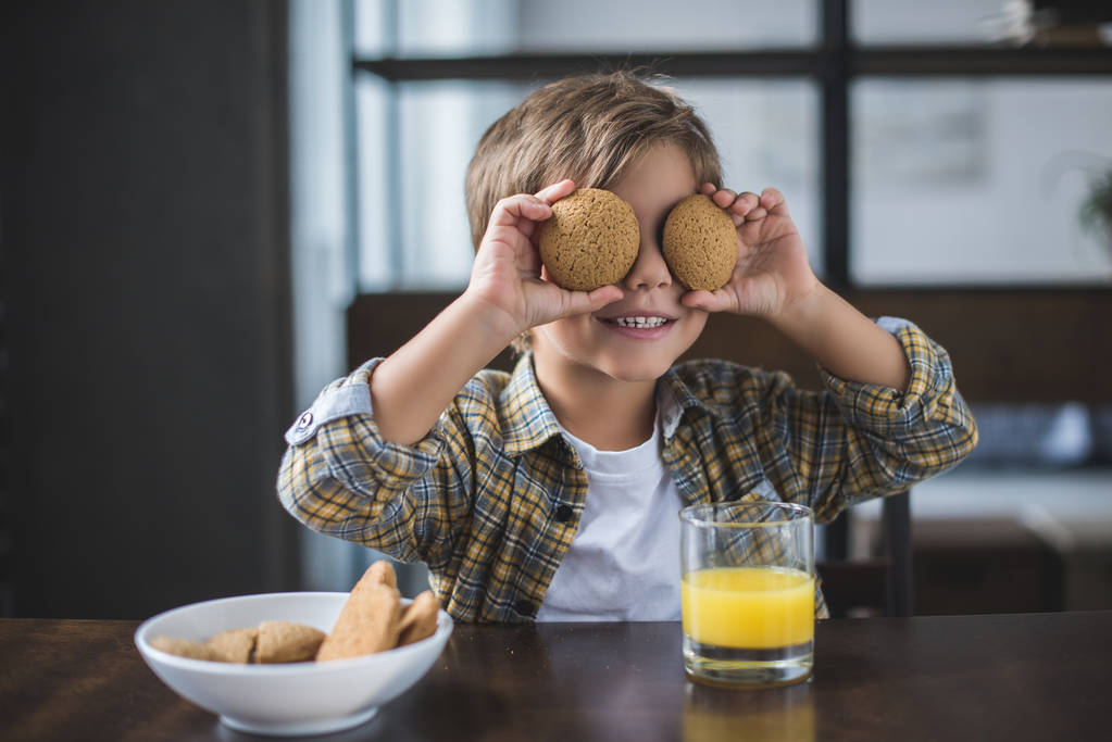 маленький хлопчик тримає печиво
 - Фото, зображення