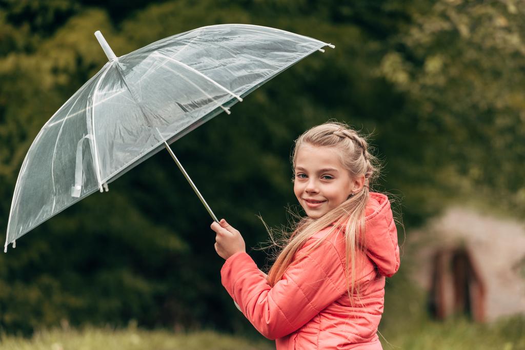 Kind mit Regenschirm im Herbstpark - Foto, Bild