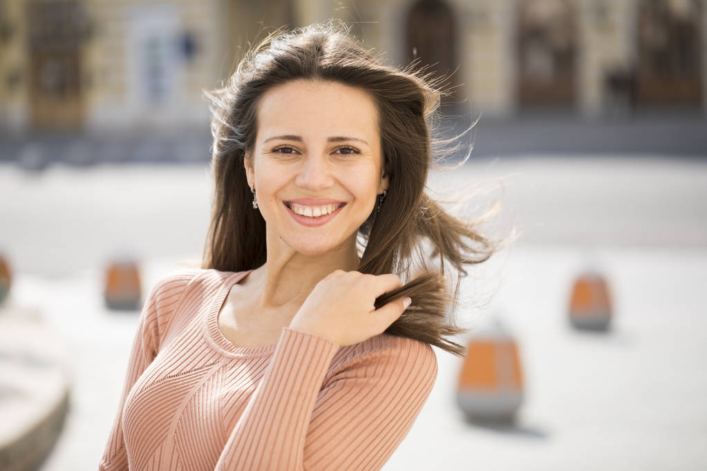 Κοντινό πορτραίτο μιας χαρούμενης νεαρής γυναίκας που χαμογελάει - Φωτογραφία, εικόνα