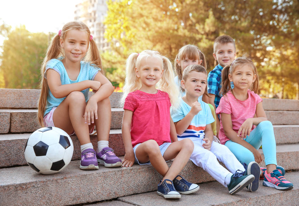 都市公園の階段の上に座ってボールをかわいい子供たち - 写真・画像