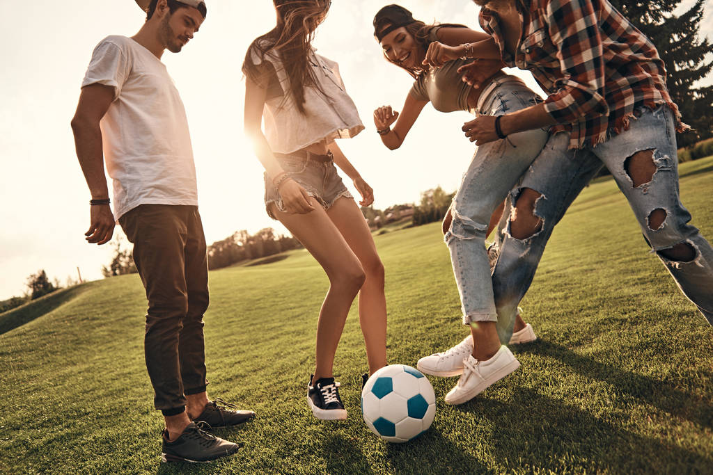 друзья в повседневной одежде играют в футбол
 - Фото, изображение