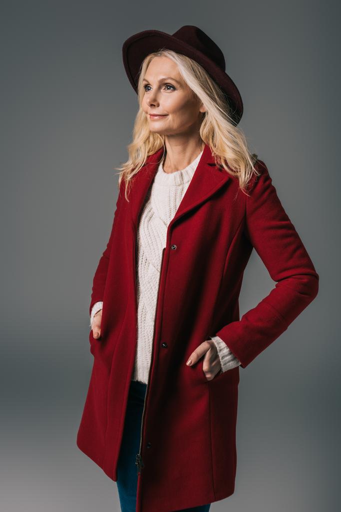 zralá žena v červeném kabátě a klobouku - Fotografie, Obrázek