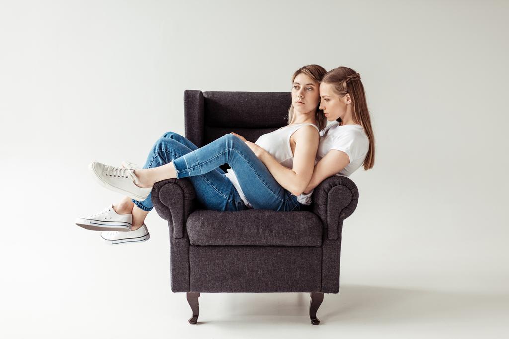 Ομοφυλόφιλο ζευγάρι κάθεται στην πολυθρόνα - Φωτογραφία, εικόνα
