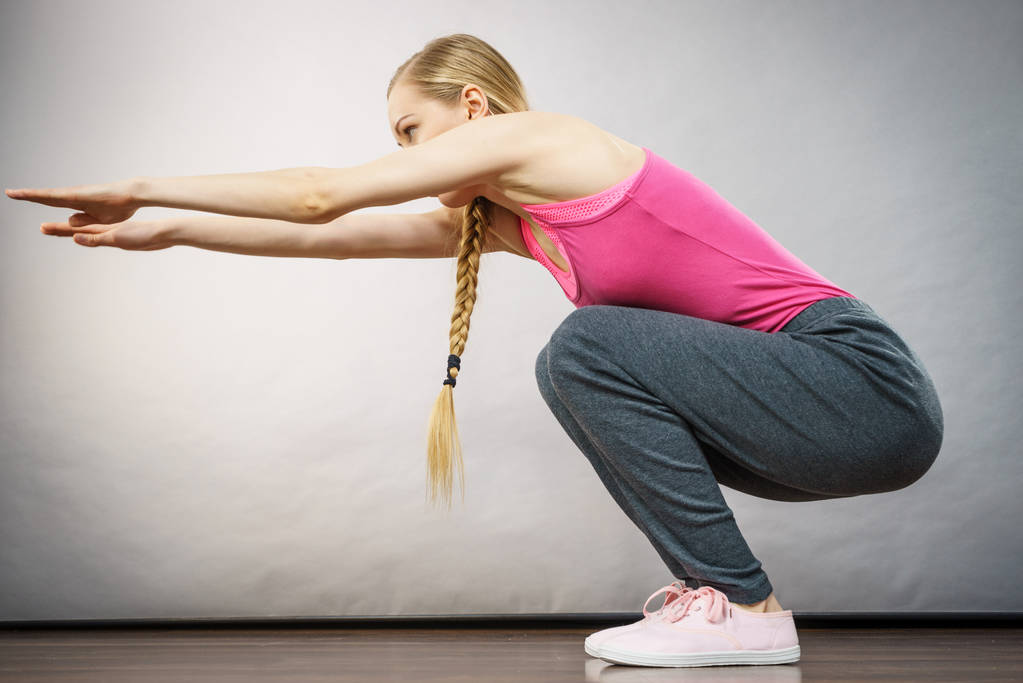 Woman training at home doing sit ups squats - Photo, Image