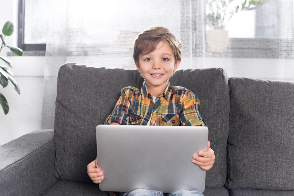 мальчик с ноутбуком сидит на диване
 - Фото, изображение