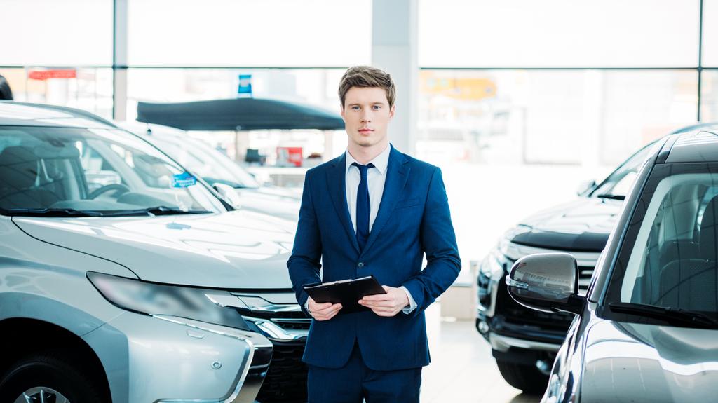 manažer, stojící mezi automobily v showroomu - Fotografie, Obrázek