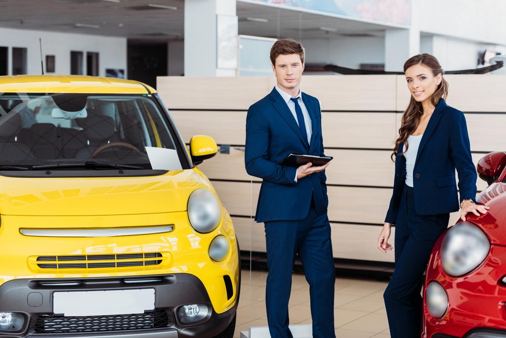 Sales managers posing in car showroom - Photo, Image