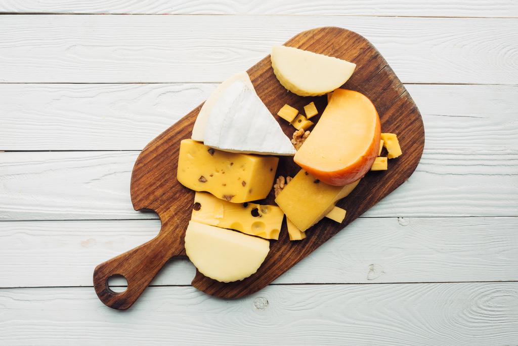 tipos variados de queso en la tabla de cortar
 - Foto, Imagen