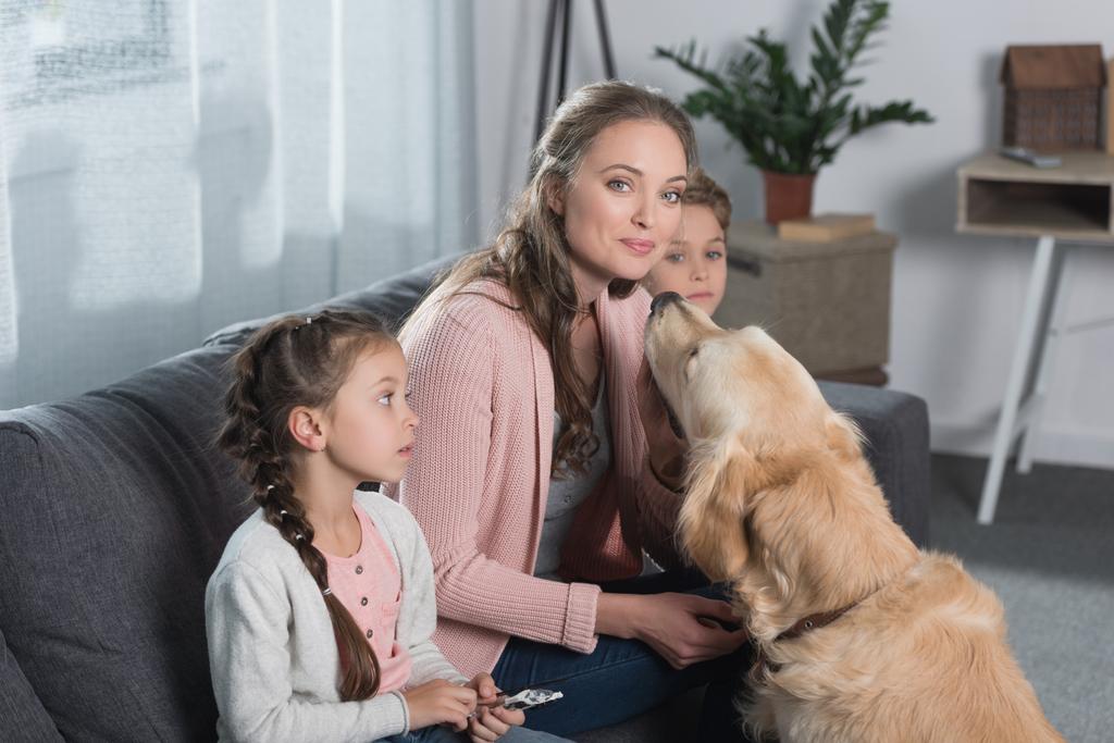 Мати сидить з дітьми і собакою
 - Фото, зображення