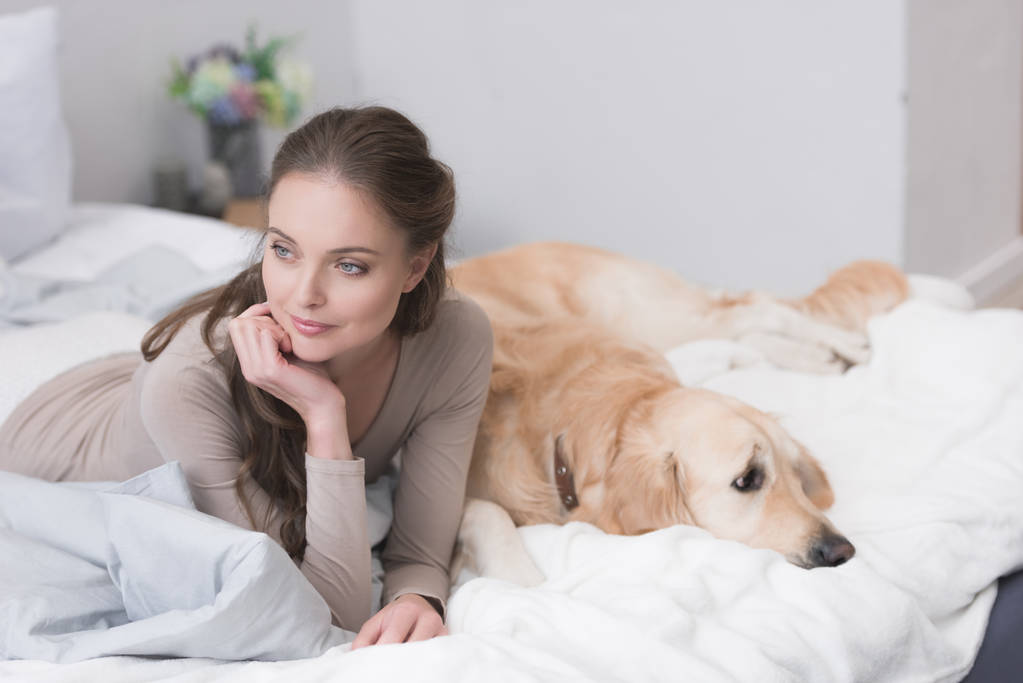 femme couchée sur le lit avec chien
 - Photo, image