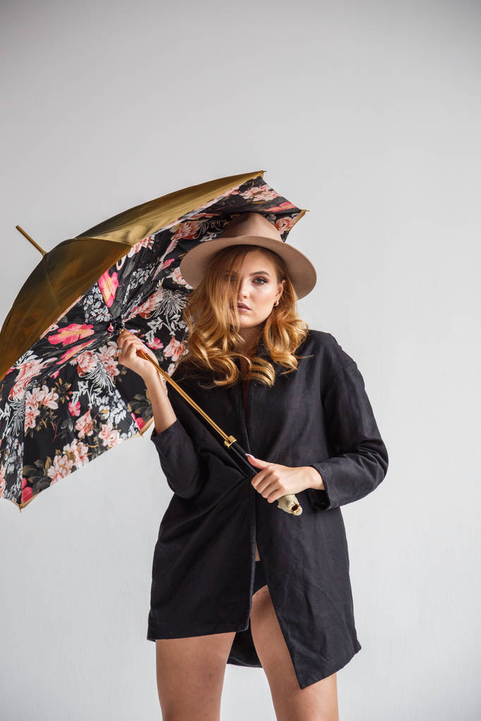 μοντέλο στη μαύρη μπλούζα και καπέλο με ομπρέλα  - Φωτογραφία, εικόνα